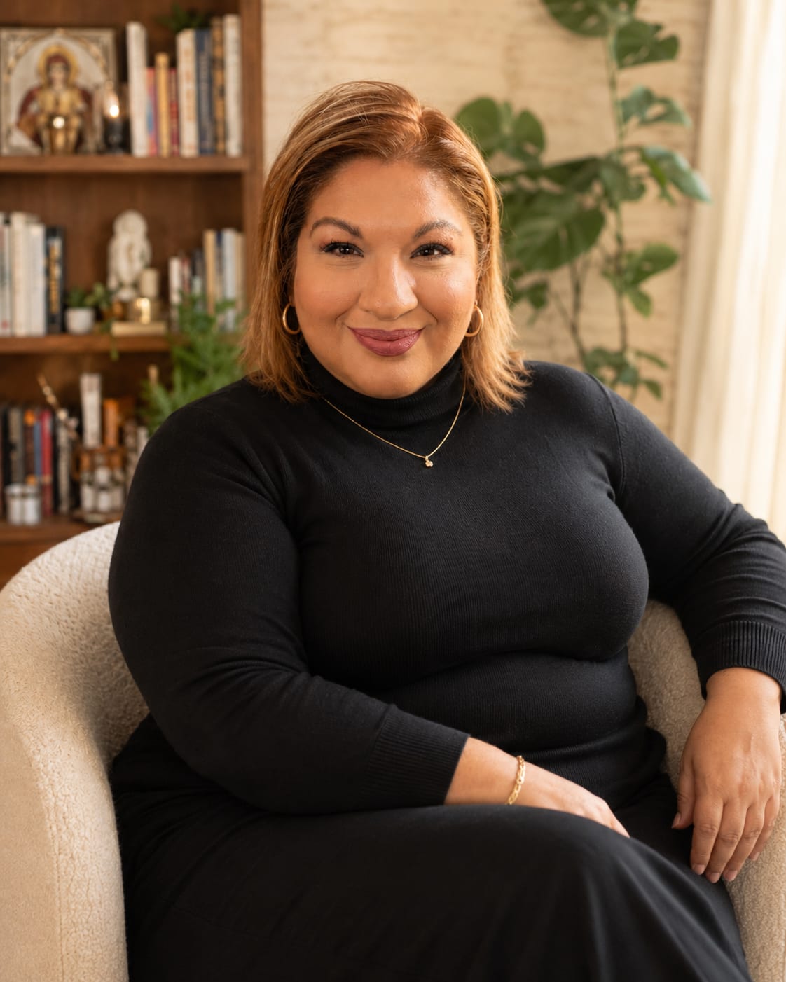 Olivia Murillo Morales, sentada en su biblioteca